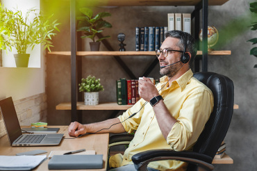 Middle aged man working from home with a laptop and home office