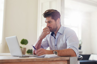 man looking at his laptop working from home